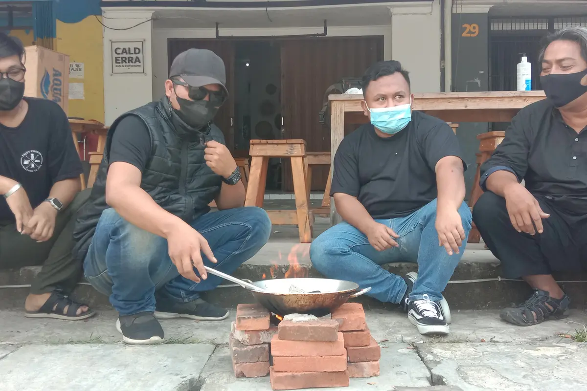 Pedagang dan Pemilik Kafe Memasak Batu Karena PPKM Diperpanjang. (Selasa, 03/08/2021). (Liputan6.com/Yandhi Deslatama).