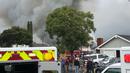 Warga melihat kobaran asap setelah pesawat Cessna 414A jatuh di sebuah rumah di Yorba Linda, California (3/2). Dilaporkan ada 4 orang tewas akibat kejadian ini, namun identitas korban belum diungkap. (AP Photo/Alex Gallardo)