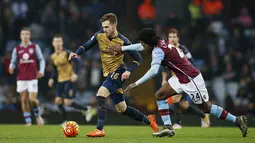 Gelandang Arsenal, Aaron Ramsey, berusaha melewati pemain Aston Villa, Carlos Sanchez, pada laga Liga Premier Inggris di Stadion Villa Park, Inggris, Minggu (13/12/2015). (Reuters/Paul Childs)