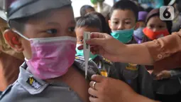 Guru memeriksa suhu tubuh seorang murid di  Taman Kanak-kanak (TK) RA Hidayatusshibyan Cinere, Depok, Kamis (5/3/2020). Mengantisipasi virus corona COVID-19, murid-murid diukur suhu tubuhnya  dan diwajibkan mencuci tangan mereka sebelum masuk kelas.  (merdeka.com/Arie Basuki)