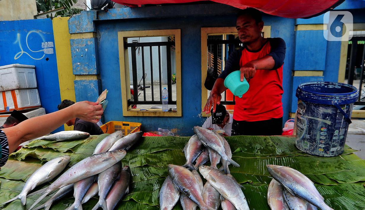 Pedagang ikan bandeng melayani pembeli di Rawa Belong, Jakarta, Jumat (20/1/2023). Penjual bandeng musiman ini menjual daganganya jelang perayaan Imlek yang dijual dengan harga mulai dari Rp. 50.000 hingga Rp. 90.000 per kilonya. (Liputan6.com/Angga Yuniar)