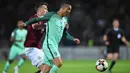 Bintang Portugal, Cristiano Ronaldo, berebut bola dengan bek Latvia, Vitalijs Jagodinskis, pada laga kualifikasi Piala Dunia 2018 di Stadion Skonto, Riga, Jumat (9/6/2017). Latvia kalah 0-3 dari Portugal. (AFP/Janek Skarzynski)