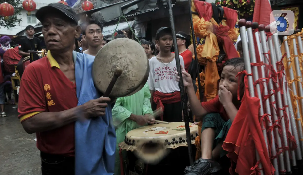 Iringan musik tradisional Tionghoa saat perayaan Cap Go Meh Tahun Baru Imlek 2571 di Jatinegara, Jakarta, Minggu (9/2/2020). Meski hujan, perayaan Cap Go Meh berlangsung meriah dengan atraksi barongsai dan liong serta arakan dewa-dewa mengelilingi kawasan Jatinegara. (merdeka.com/Iqbal S Nugroho)