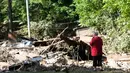 Emma Allen (58) mengamati puing rumahnya yang dilanda banjir dahsyat di Falling Rock, Virginia Barat, Minggu (26/6). Status darurat sudah dinyatakan di 44 dari 55 wilayah setingkat kota di negara bagian tersebut. (REUTERS/Marcus Constantino)