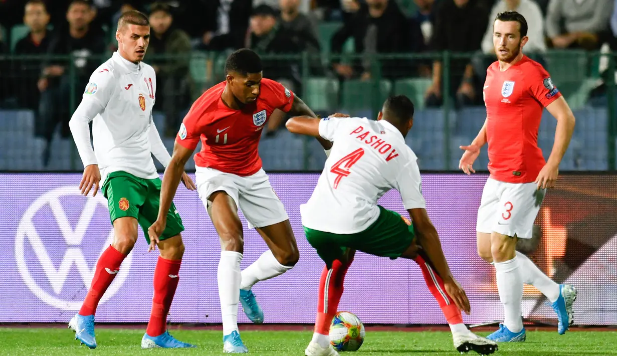 Striker Inggris, Marcus Rashford, berusaha menghadang bek Bulgaria, Georgi Pashov, pada laga Kualifikasi Piala Dunia 2020 di Stadion Vasil Levski, Sofia, Senin (14/10). Bulgaria kalah 0-6 dari Inggris. (AFP/Nikolay Dychinov)