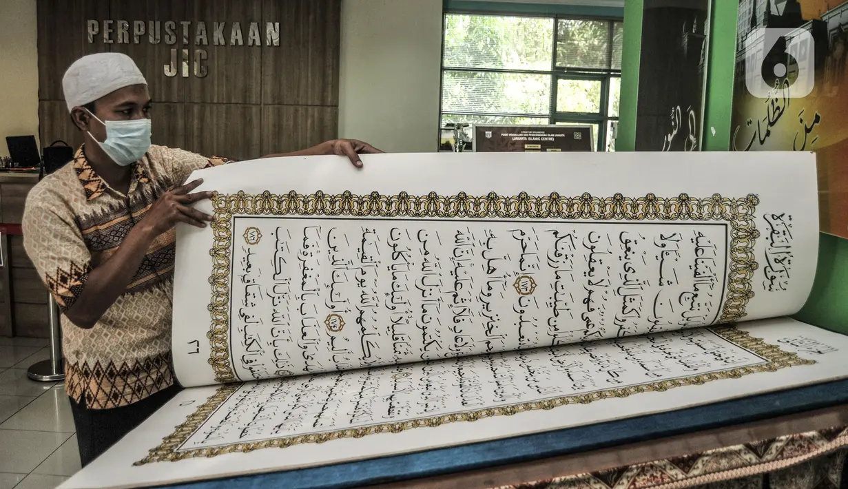 Petugas membaca sepenggal ayat dari Alquran raksasa koleksi Perpustakaan Jakarta Islamic Center (JIC), Jakarta Utara, Kamis (22/4/2021). Alquran tersebut berukuran 142 cm x 95 cm dan terdiri dari 604 halaman. (merdeka.com/Iqbal S Nugroho)