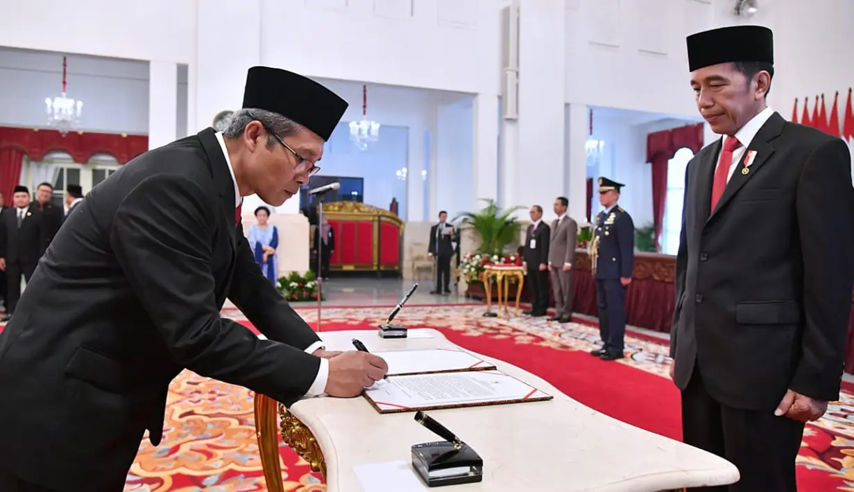 Wakil Ketua KPK periode 2019-2023 Alexander Marwata (kiri) menandatangani nota pelantikan disaksikan Presiden Joko Widodo di Istana Negara, Jakarta, Jumat (20/12/2019). Upacara pelantikan lima pimpinan KPK periode 2019-2023 dipimpin langsung Presiden Joko Widodo. (Foto: Biro Pers Setpres)