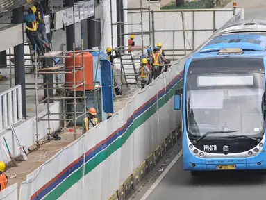 Bus Transjakarta melintas di samping proyek revitalisasi halte TransJakarta Gelora Bung Karno (GBK), Jakarta Pusat, Senin (25/7/2022). PT TransJakarta terus mengebut proyek konstruksi revitalisasi sembilan halte yang akan berlangsung sekitar enam bulan dan akan difungsikan kembali secara bertahap sampai dengan dirampungkan secara keseluruhan pada Desember 2022. (merdeka.com/Iqbal S Nugroho)