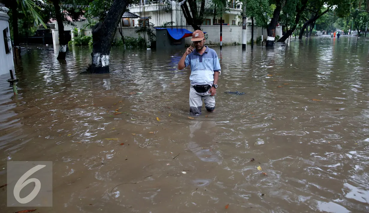 Warga melintasi banjir yang menggenangi Kommplek Perumahan yang Banjir di Hang Lekiu, Kebayoran Baru, Jakarta, Jumat (11/11). Hujan deras yang mengguyur Jakarta sejak siang tadi menyebabkan sejumlah wilayah tergenang banjir. (Liputan6.com/Johan Tallo)