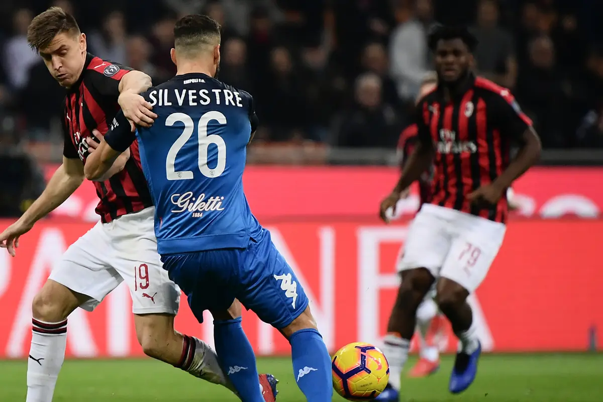 Striker AC Milan, Krzysztof Piatek, berusaha melewati bek Empoli, Matias Silvestre, pada laga Serie A. (AFP/Marco Bertorello)