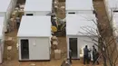 Pekerja menyiapkan kontainer untuk bangsal merawat orang yang terinfeksi corona COVID-19 di halaman Pusat Medis Seoul, Kamis (10/12/2020). Otoritas Korea Selatan membuat tempat tidur rumah sakit dari kontainer untuk meringankan beban fasilitas medis yang telah kewalahan. (AP Photo/Ahn Young-joon)