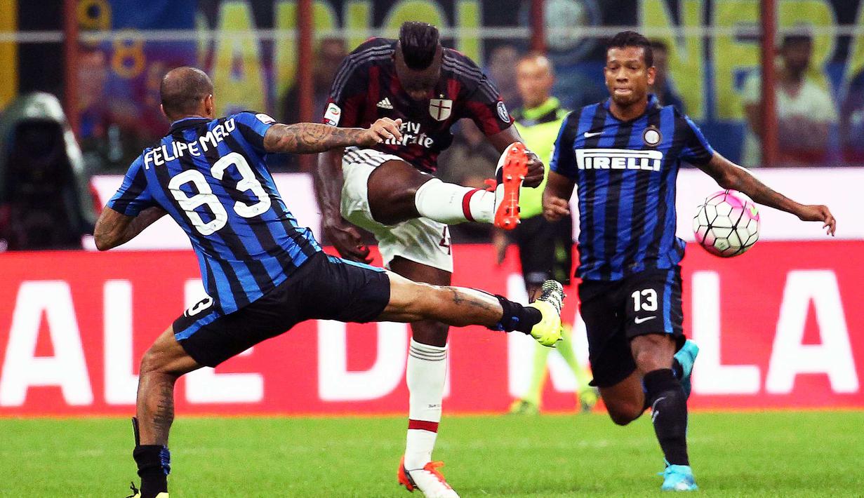 Penyerang AC Milan, Mario Balotelli (tengah) berusaha melewati pemain Inter Milan, Felipe Melo pada lada Derdy della Madonnina, di Stadion Giuseppe Meazza.  (EPA/Matteo Bazzi)