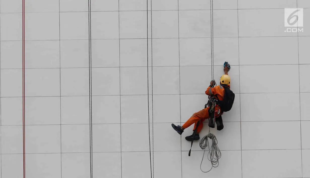 Seorang pekerja membersihkan salah satu gedung bertingkat di Bundaran Hotel Indonesia, Jakarta, Rabu (14/3). BPJS Ketenagakerjaan mendorong meminimalisir kecelakaan kerja melalui Keselamatan dan Kesehatan Kerja (K3). (Liputan6.com/Angga Yuniar)