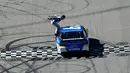 Pembalap Carl Edwards bersiap untuk melakukan aksi berbahaya dengan bersalto dari mobil ketika mesin dalam keadaan berjalan usai merayakan kemenangan NASCAR Sprint Cup Series Food City 500 di Bristol Motor Speedway (17/4). (AFP/Matt Sullivan)
