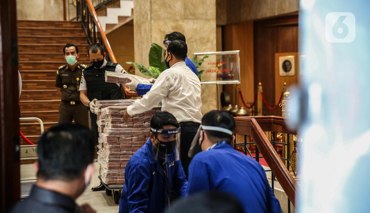 Petugas memindahkan tumpukan uang saat rilis eksekusi barang bukti Honggo Wendratno di Kejaksaan Agung RI, Jakarta, Selasa (7/7/2020). Kejagung menyita barang bukti uang Honggo Wendratno sebesar Rp 97 miliar. (Liputan6.com/Faizal Fanani)