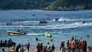 Dikenal sebagai salah satu titik selancar terbaik di Indonesia, Lhoknga memiliki ombak yang menantang dengan ketinggian rata-rata 1,5 hingga 2 meter. Tampak dalam foto, orang-orang saat berkumpul menikmati masa libur panjang Idulfitri di area olahraga air, Pantai Lhoknga, Aceh, pada Kamis 26 Maret 2026. (Chaideer MAHYUDDIN/AFP)