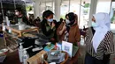Pengunjung dengan menggunakan bahasa isyarat memesan makanan di Kafe Serona Bintaro, Tangerang Selatan, Kamis (7/10/2021). Kafe Serona merupakan tempat makan yang mempekerjakan 8 penyandang tuna rungu sebagai tempat berintraksi teman tuli dan juga masyarakat umum. (merdeka.com/Arie Basuki)