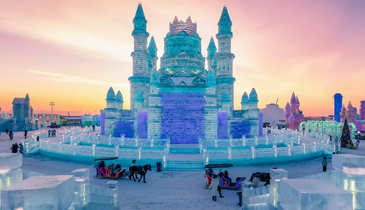 Foto pada 24 Desember 2018 menunjukkan orang-orang mengunjungi Harbin Ice Snow World di Harbin, provinsi Heilongjiang, China. Festival pameran es dan salju terbesar di dunia ini secara resmi akan dibuka 4 Januari 2019. (STR / AFP)