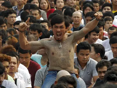 Pria bertato dalam keadaan kesurupan mengikuti Festival Tato Sihir di Wat Bang Phra, Nakhon Pathom, Bangkok, Thailand (19/3). Ribuan orang datang untuk memberikan penghormatan pada penguasa tato. (REUTERS/Chaiwat Subprasom)