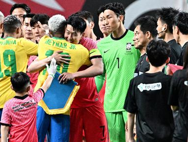 Momen unik terjadi saat laga persahabatan antara Korea Selatan melawan Brasil di Seoul's Sang-am Stadium, Seoul, Korea Selatan, Kamis (01/06/2022) malam WIB. Meski kalah dengan skor 1-5, pertandingan tersebut terasa istimewa bagi Son Heung-min karena mampu berjumpa dengan idolanya, Neymar. (AFP/Anthony Wallace)