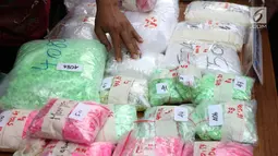 Petugas Ditresnarkoba Polda Metro Jaya memperlihatkan barang bukti penangkapan vokalis grup band Zivilia, Zulkifli alias Zul, Jakarta, Jumat (8/3). Zul ditangkap terkait penyalahgunaan narkotika, Kamis (28/2) lalu. (Liputan6.com/Helmi Fithriansyah)