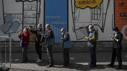Orang-orang memindai kode QR untuk mendaftar tes COVID-19 pada tempat pengujian setelah pihak berwenang memerintahkan putaran ketiga dari tiga tes COVID-19 berturut-turut untuk penduduk di Distrik Chaoyang, Beijing, China, Sabtu (7/5/2022). (AP Photo/Mark Schiefelbein)