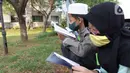 Anak-anak membaca Al-Quran sambil menunggu waktu berbuka puasa di halaman Masjid Raya Jakarta Islamic Center, Jakarta Utara, Senin (18/4/2022). Acara ngabuburit sambil khataman Al-Quran ini merupakan rangkaian acara menyambut 17 Ramadhan atau malam Nuzulul Quran. (Liputan6.com/Herman Zakharia)