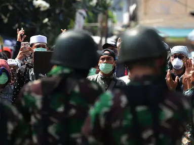 Personel TNI berdiskusi dan rekonsiliasi dengan warga untuk mencegah kerusuhan susulan di Jalan KS Tubun, Petamburan, Jakarta, Rabu (22/5/2019). Aparat keamanan berhasil menghalau massa aksi 22 Mei yang sebelumnya berkumpul di kawasan tersebut. (merdeka.com/Imam Buhori)