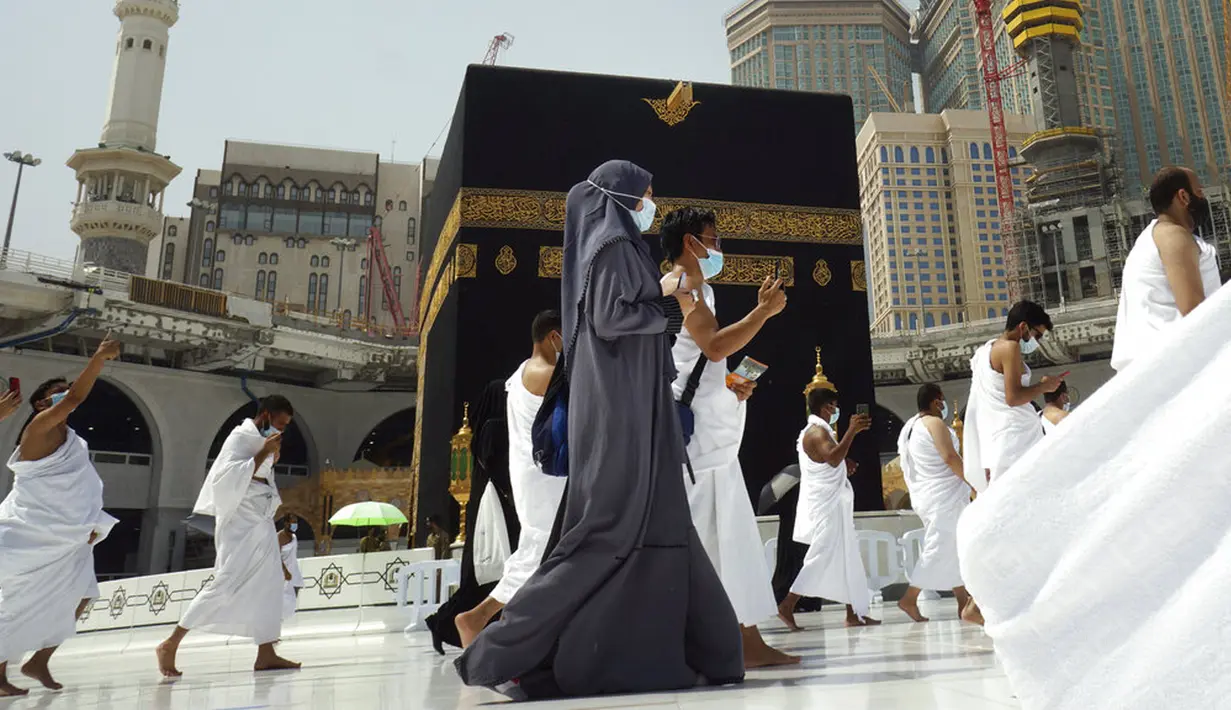 Umat muslim mengelilingi Kakbah mengenakan masker dan menjaga jarak untuk membantu menghentikan penyebaran virus corona COVID-19 saat pelaksanaan umrah di Masjidil Haram, Makkah, Arab Saudi, Minggu (30/5/2021). (AP Photo/Amr Nabil)