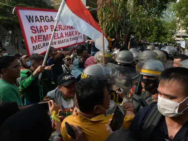 Polisi terlibat saling dorong dengan warga saat melakukan eksekusi lahan rumah warga Kelurahan Pulogebang RT 20 RW 06 (dahulu RT 08/RW 06) di Jakarta, Selasa (8/6/2021). Eksekusi lahan tersebut berakhir ricuh. (merdeka.com/Imam Buhori)
