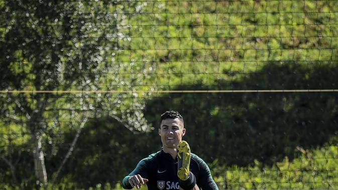 Penyerang Portugal, Cristiano Ronaldo, saat latihan jelang laga kualifikasi Piala Eropa di Lisbon, Selasa (19/3). Portugal akan berhadapan dengan Ukraina. (AFP/Patricia Del Melo Moreira)