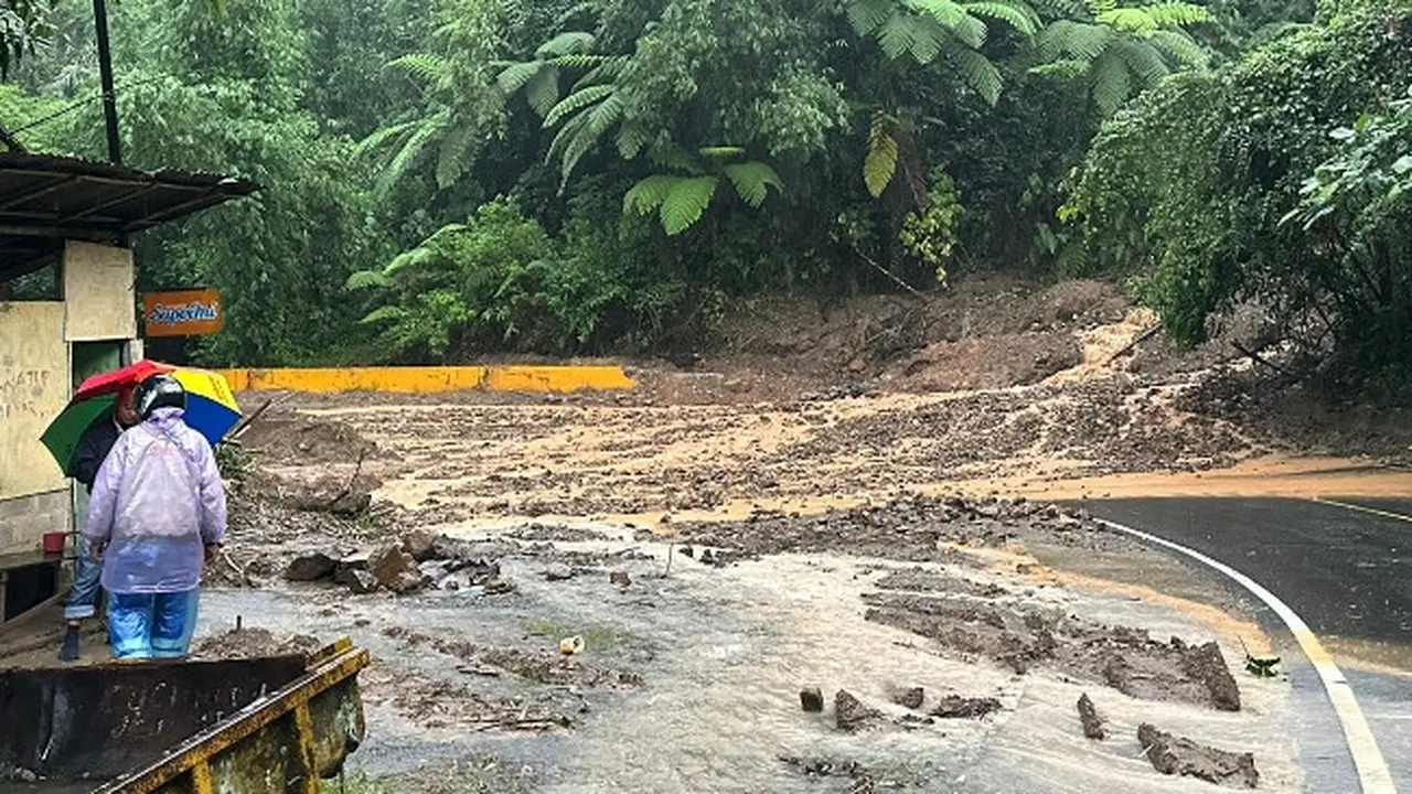Jalan lintas Riau-Sumbar yang putus karena longsor sehingga petugas melakukan penutupan sementara.