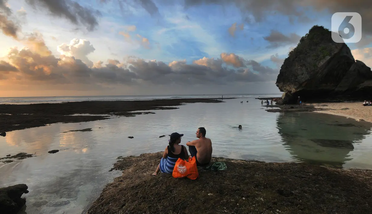 Wisatawan menikmati kolam renang alami yang terbentuk saat air laut surut di kawasan Pantai Suluban, Uluwatu, Bali, Selasa (7/9/2021). Keunikan Pantai Suluban dengan kolam-kolam yang terbentuk di atas karang menjadi daya tarik wisatawan. (merdeka.com/Arie Basuki)