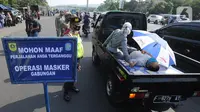 Petugas memperhatikan warga sakit yang dievakuasi dengan mobil saat Operasi Masker Gabungan di Perempatan Ciawi, Bogor, Kamis (10/9/2020). Razia masker yang dilakukan Pemkot dan Pemkab Bogor ini menyasar warga yang tidak mengenakan masker dengan denda sebesar Rp 100.000. (merdeka.com/Arie Basuki)