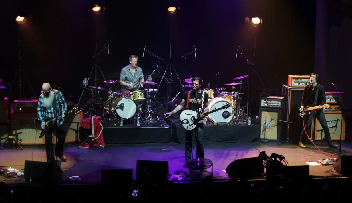 Penampilan grup rock Eagles of Death Metal di atas panggung gedung teater Olympia, Paris, Selasa (16/2). Grup rock asal California itu menggelar konser di hadapan ratusan penggemar yang selamat dari serangan teror pada November lalu (AFP PHOTO/Joel SAGET)