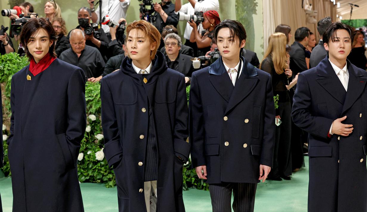Stray Kids berjalan di atas karpet merah dengan mengenakan mantel berwarna hitam. (Marleen Moise / GETTY IMAGES NORTH AMERICA / Getty Images via AFP)