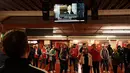 Fans mendengarkan televisi saat Perdana Menteri Inggris Liz Truss membacakan pernyataan di Downing Street, menyusul berita bahwa Ratu Elizabeth II telah meninggal, menjelang pertandingan sepak bola Grup E UEFA Europa League antara Manchester United dan Real Sociedad, di stadion Old Trafford, di Manchester, pada 8 September 2022. (AFP/Oli Scarff)