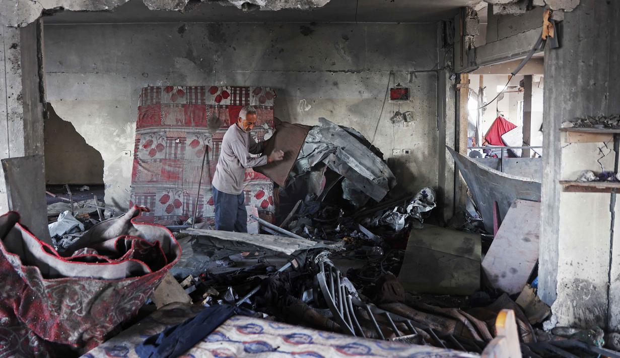 Juru bicara Pertahanan Sipil Gaza, Mahmoud Basal, mengatakan serangan Israel menargetkan berbagai lokasi sejak siang hari. Tampak dalam foto, seorang pria Palestina memeriksa puing-puing bangunan yang rusak milik Kementerian Wakaf Agama, yang digunakan sebagai tempat penampungan bagi pengungsi di kawasan Zeitoun, Kota Gaza, pada Kamis 20 November 2025, sehari setelah bangunan tersebut menjadi sasaran serangan militer Israel. (Omar AL-QATTAA /AFP)