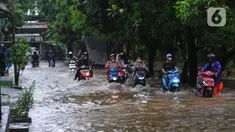 Sejumlah pengendara motor melintasi banjir di Jalan Benteng,  Duta Kranji, Kalibaru, Bekasi, Jawa Barat, Jumat (24/2/2023). Jalan yang dilalui oleh para pengendara masih digenangi air ditambah dari luapan kalibaru Duta Kranji akibat hujan deras yang mengguyur Kota Bekasi sejak Kamis (23/2/2023) malam. (merdeka.com/Imam Buhori)