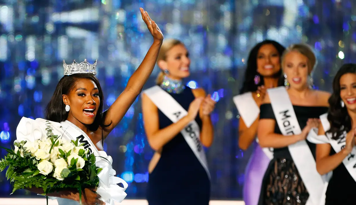 Miss New York Nia Franklin melambaikan tangan ke penonton usai dinobatkan sebagai Miss America 2019 di Atlantic City, New Jersey (9/10). Franklin 24 tahun telah menyelesaikan sarjana komposisi musik di East Carolina University. (AP Photo/Noah K. Murray)