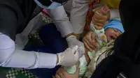 Seorang petugas kesehatan memberikan vaksin campak kepada balita di sebuah posyandu di Banda Aceh, Aceh, Rabu (4/10/2020). Pemberian vaksin polio dan vaksin campak secara gratis yang berlanjut di tengah pandemi COVID-19 bertujuan memperkuat imunitas anak. (CHAIDEER MAHYUDDIN / AFP)