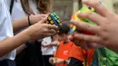 Permainan Kubus Rubik berguna untuk meningkatkan perkembangan kinerja otak yang terwujud dalam kemampuan berpikir logis, kreatif, strategis, komunikatif, serta mengembangkan ketelitian dan konsentrasi. (Ferenc ISZA/AFP)