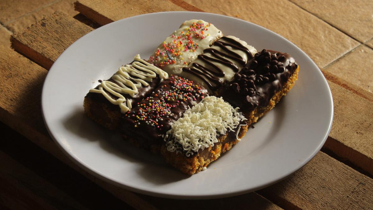 Pisang Nugget Renyah: Potongan pisang nugget yang renyah di luar dan lembut di dalam, disajikan dengan topping cokelat leleh yang menggoda