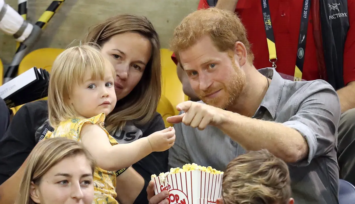 Pangeran Harry saat bercengkrama dengan Emily saat menyaksikan Invictus Games 2017 di Toronto, Kanada, Rabu (27/9). Aksi tersebut menjadi viral lantaran banyak yang gemas melihat interaksi Pangeran Harry dengan Emily. (CHRIS JACKSON/GETTY IMAGES/AFP)