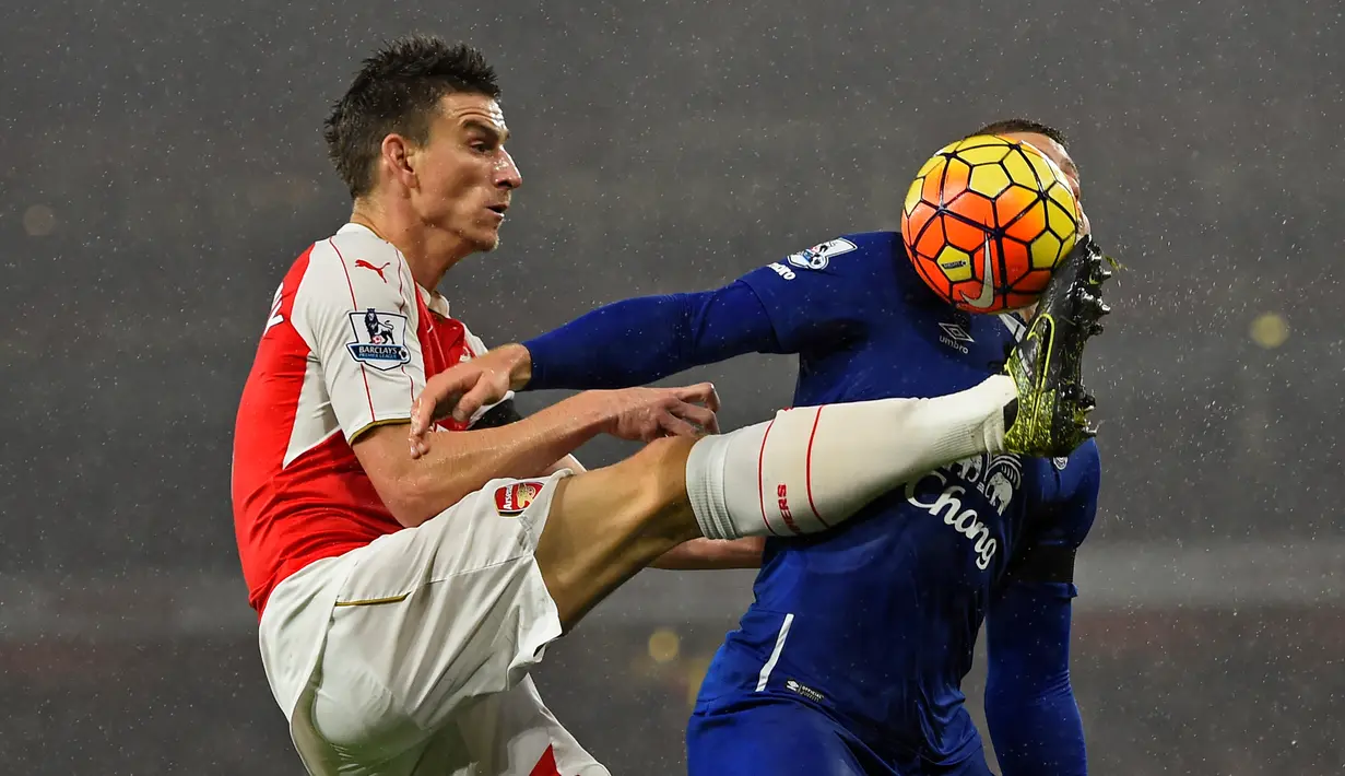 Pemain Arsenal, Laurent Koscielny, berebut bola dengan pemain Everton dalam lanjutan Liga Premier Inggris di Stadion Emirates, London, Inggris. Sabtu (24/10/2015) malam WIB. (Reuters/ Dylan Martinez)