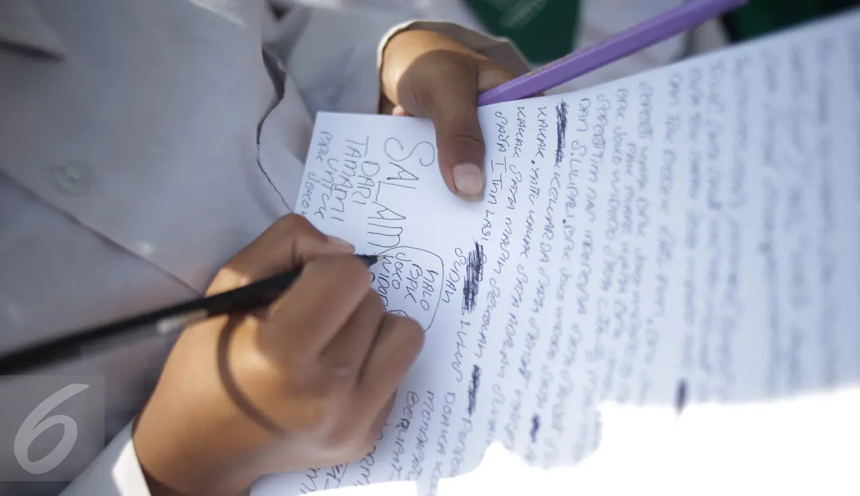 Murid Madrasah Ibtidayah (MI) Yayasan Nurul Bahri menulis surat untuk Presiden Jokowi, di perkampungan nelayan Muara Angke, Jakarta, Senin (27/2). Kegiatan itu sebagai ajakan agar anak Indonesia gemar menulis. (Liputan6.com/Faizal Fanani)