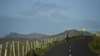 Seorang wanita berjalan menyusuri jalan di Coumeenoole, Irlandia, Selasa (27/12). Irlandia mendapat julukan Pulau Zamrud karena memiliki pemandangan alam yang hijau terang. (REUTERS / Clodagh Kilcoyne)