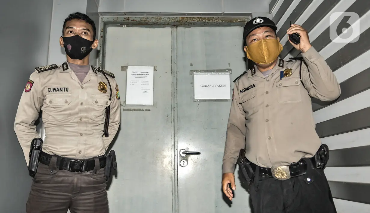 Petugas kepolisian berjaga di depan ruang penyimpanan vaksin Covid-19 di Kantor Dinas Kesehatan DKI Jakarta, Kamis (7/1/2021). Dinas Kesehatan DKI Jakarta pada tahap I telah menerima sebanyak 78.400 vaksin Covid-19 dari Sinovac yang diprioritaskan untuk tenaga kesehatan. (merdeka.com/Iqbal Nugroho)