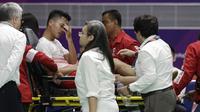 Pebulutangkis Indonesia, Anthony Ginting, ditandu keluar lapangan karena cedera saat melawan wakil China, Shi Yuqi, pada laga final bulutangkis beregu putra Asian Games di Istora, Jakarta, Rabu (22/08/2018). (AP/Aaron Favila)