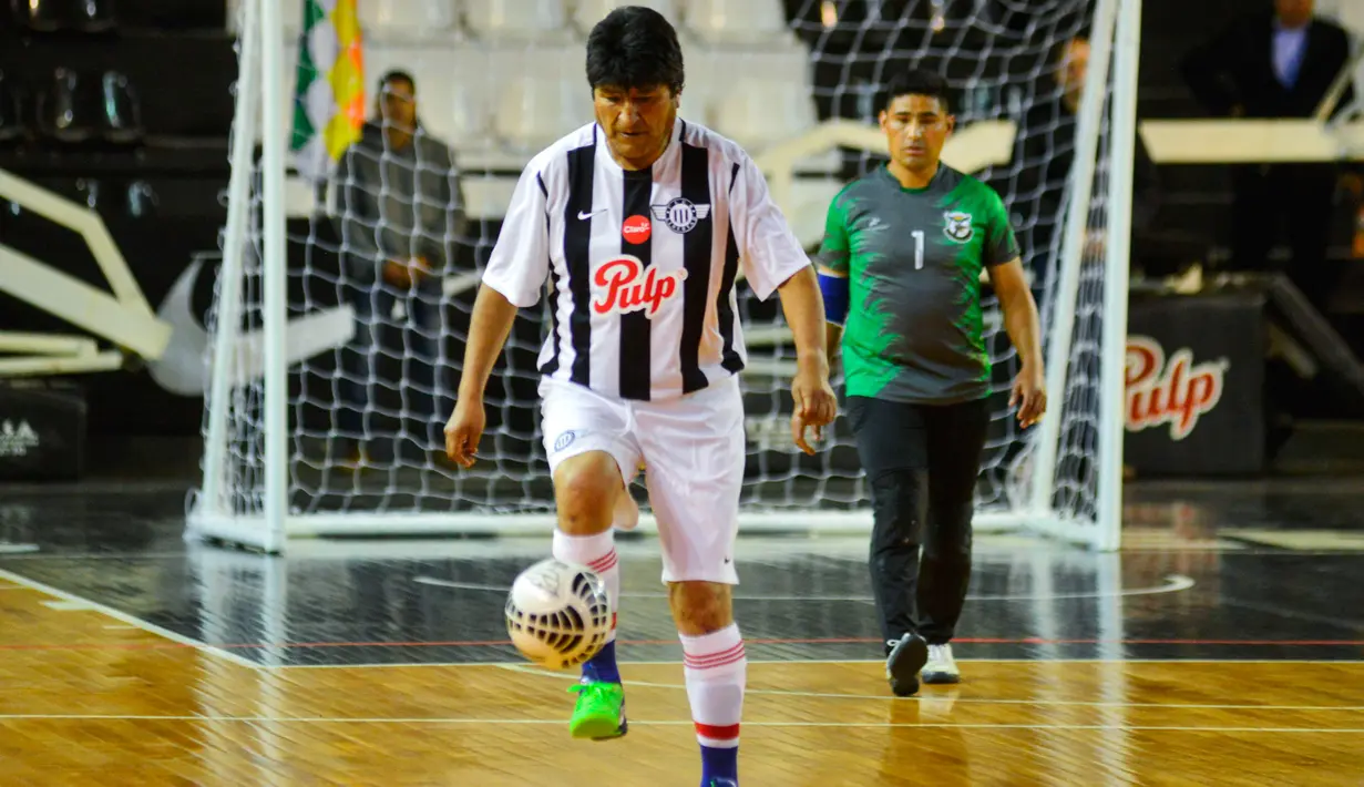 Presiden Bolivia Evo Morales mengontrol bola saat pertandingan persahabatan melawan anggota komunitas Bolivia setempat selama kunjungannya di Asunción, Paraguay, (14/8). (AFP Photo/Silvio Rojas)